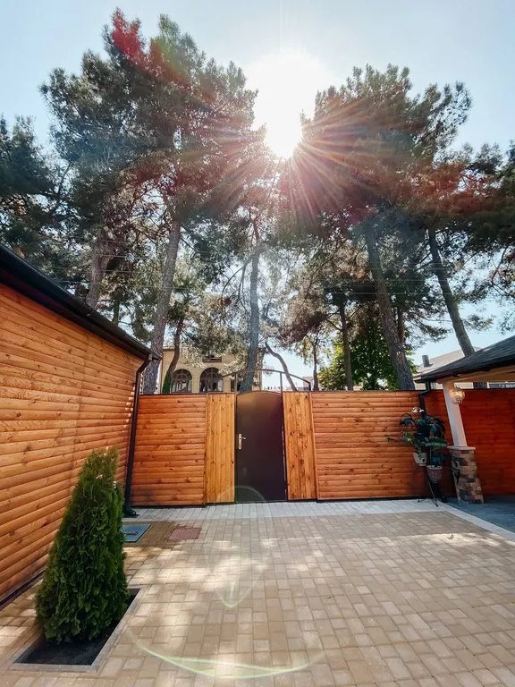 2 деревянных домика из сруба с беседкой-барбекю во одном дворе