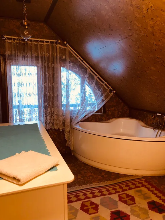 Изба (дом) из экологически чистого бревна под камышовой крышей в лесу