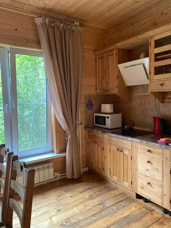 Деревянный дом на берегу реки с беседкой