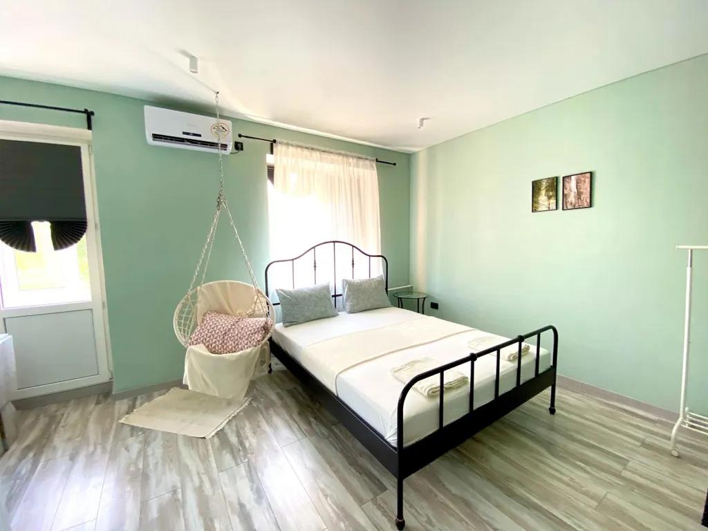 Уютная студия с качелями и видом на тихий зеленый сад