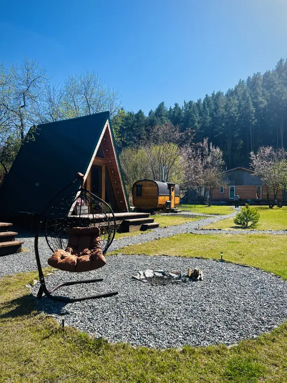 Уютный а-фрейм в сердце гор Алтая с видом на горы у леса