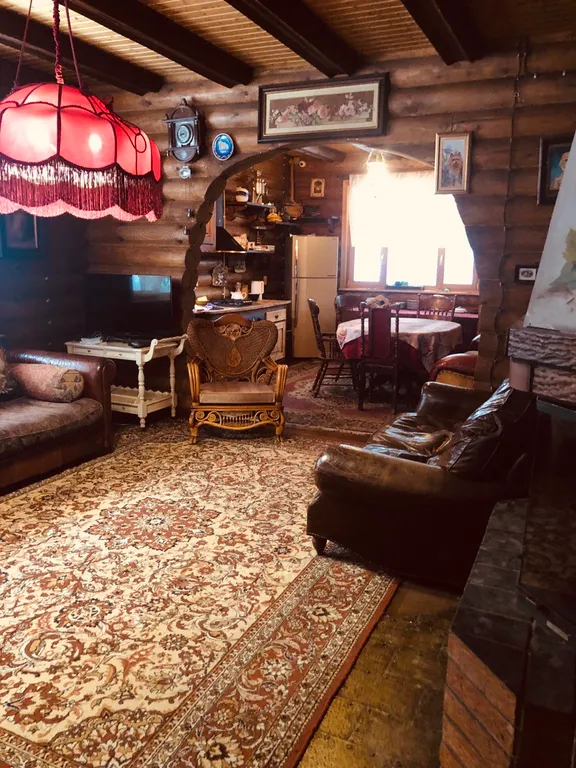 Изба (дом) из экологически чистого бревна под камышовой крышей в лесу