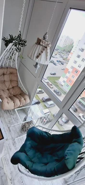 Квартира с подвесными креслами из ротанга на панорамной лоджии