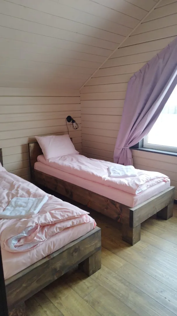 Спальная комната на втором этаже с двумя односпальными кроватями.