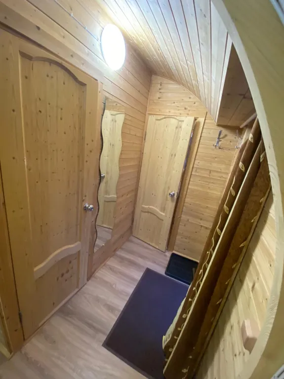 Арочный домик на краю леса с центральным входом