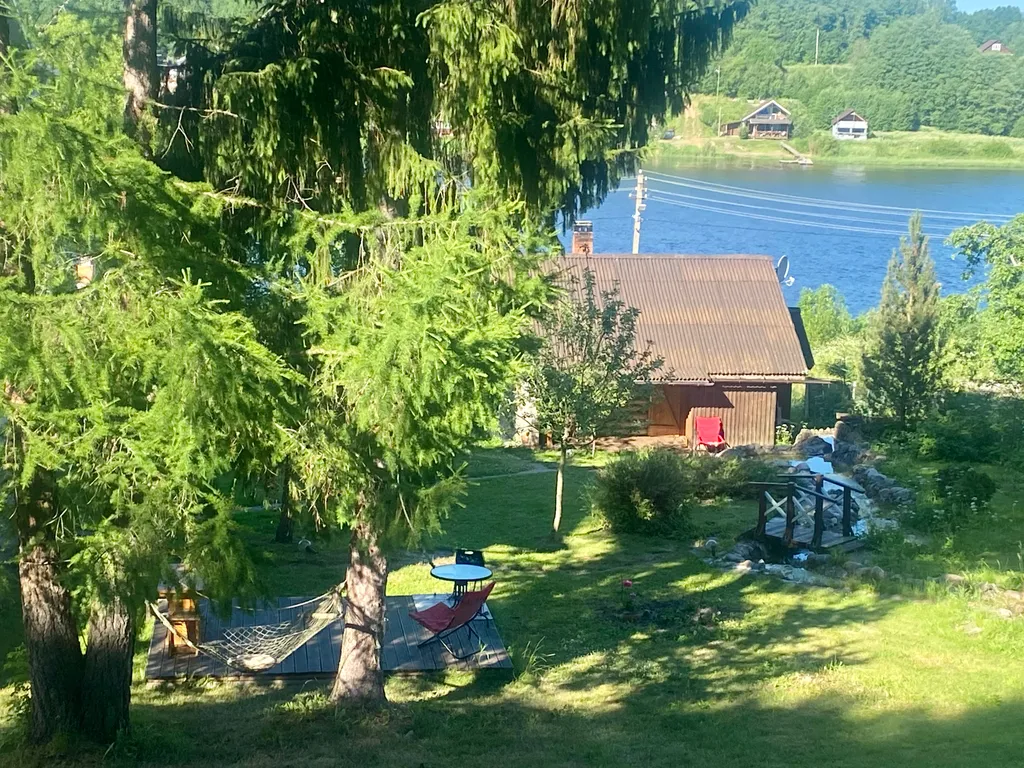 Усадебный дом с видом на реку, берег с мостками и рыбной ловлей