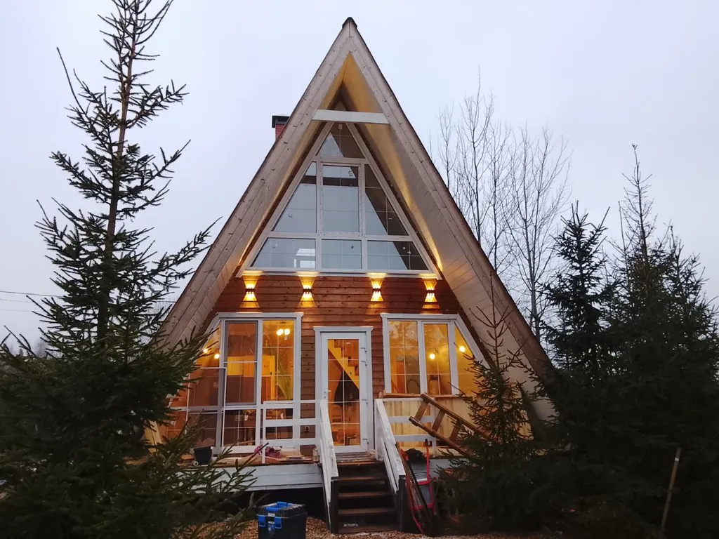 Большой дом А-Фрейм среди молодого елового леса