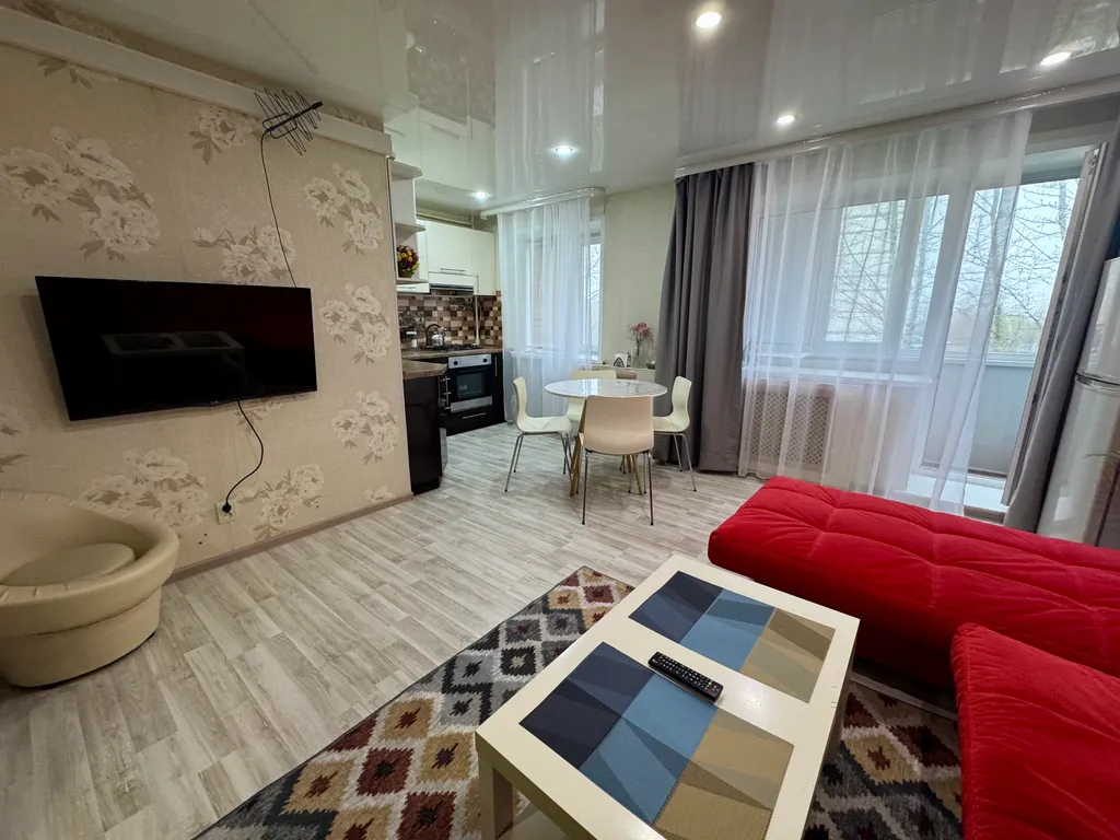 Двухкомнатная студия с красным диваном в центре города