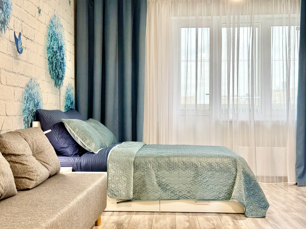 Уютная квартира-студия с большой кроватью и диваном