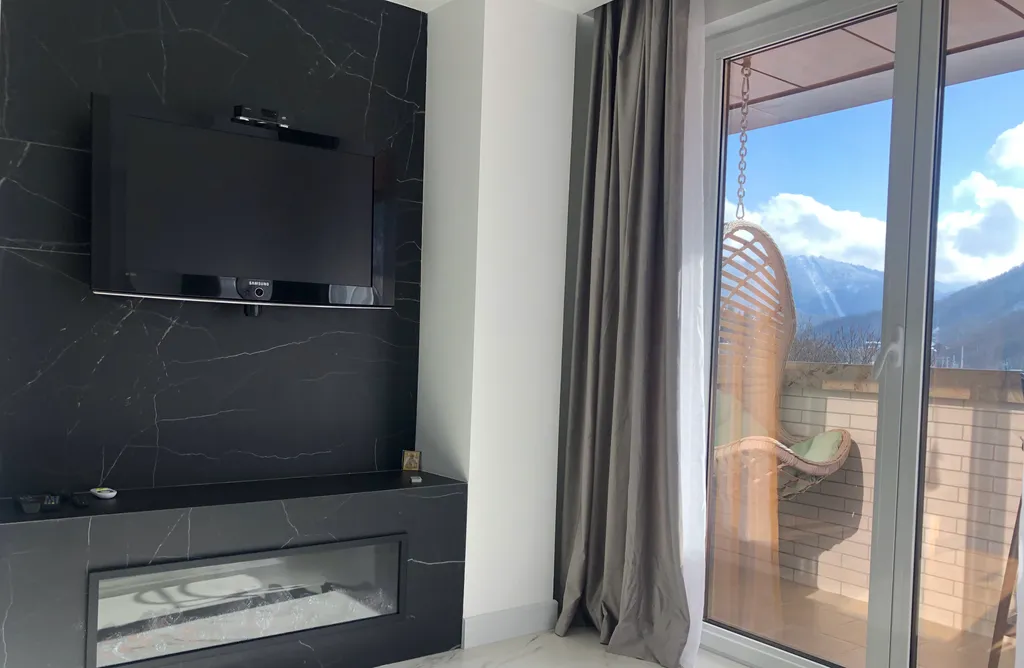 Стильная студия с ванной у панорамного окна и видом на горы