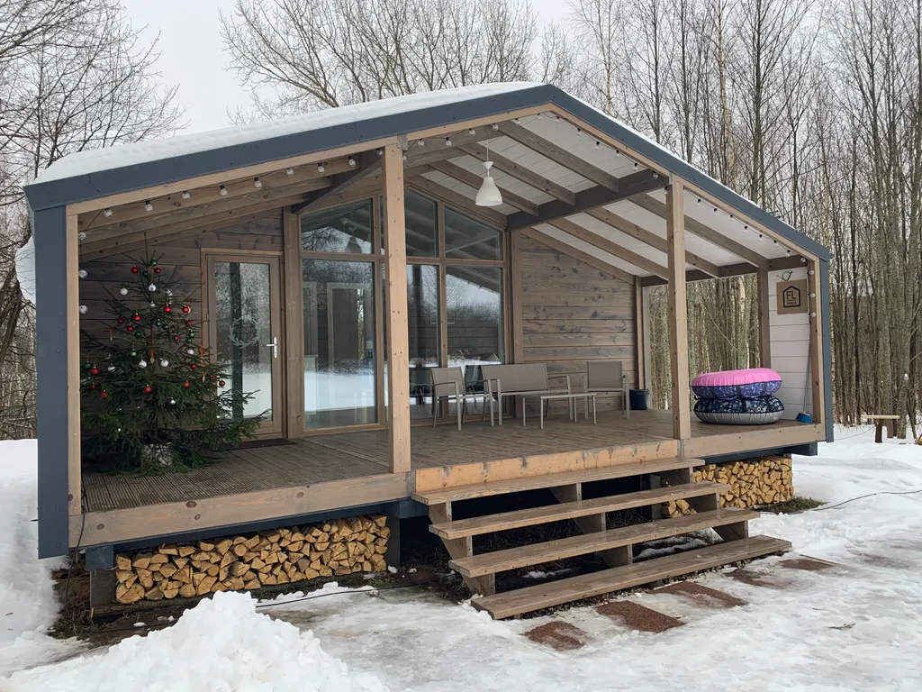 Дом с панорамными окнами в окружении леса