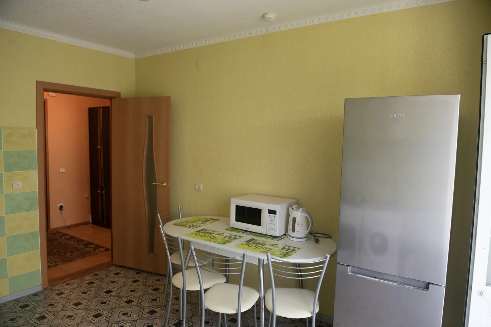 Просторная кухня: современная и удобная обеденная зона, стол, стулья, СВЧ-печь, вместительный холодильник, электрочайник