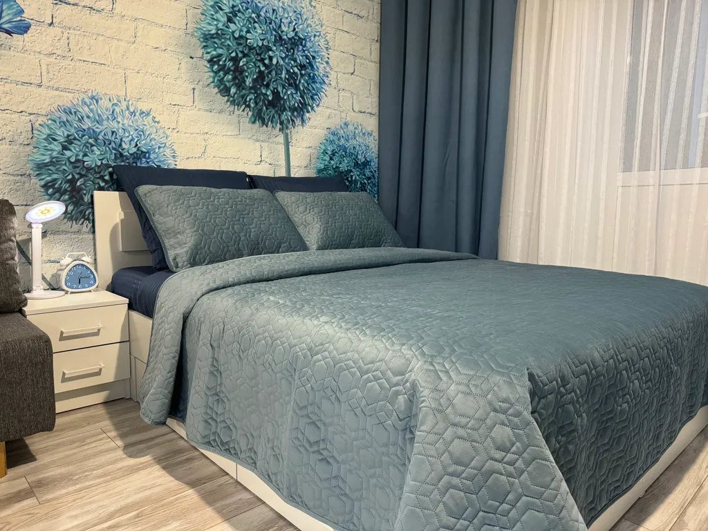 Уютная квартира-студия с большой кроватью и диваном