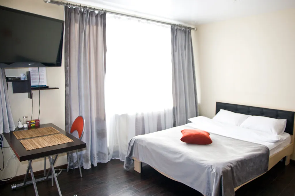 Яркая теплая студия с красным диваном