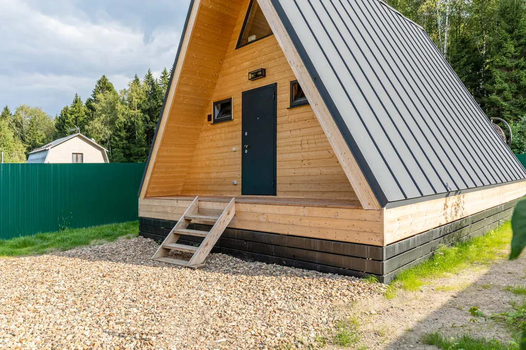 Дом шалаш в окружении леса рядом с озером