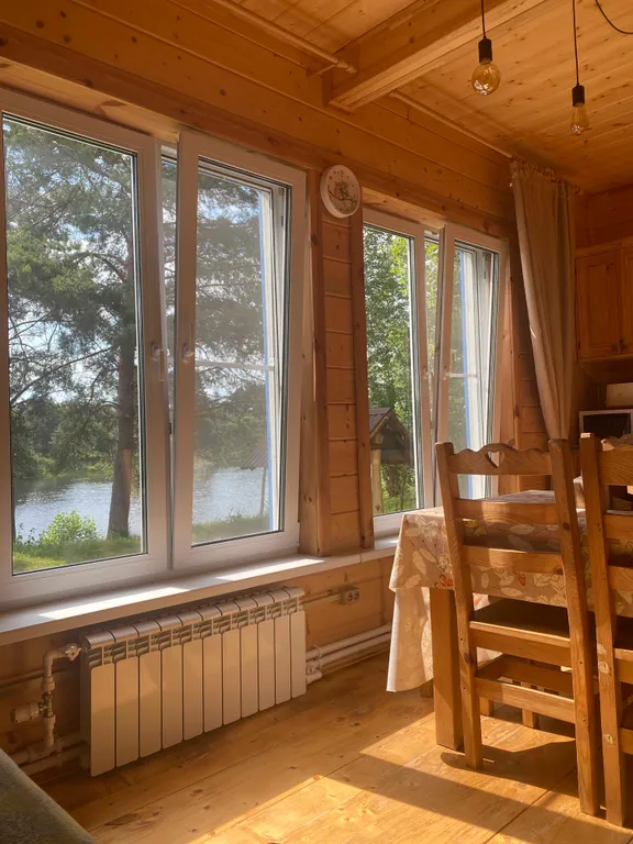 Деревянный дом на берегу реки с беседкой