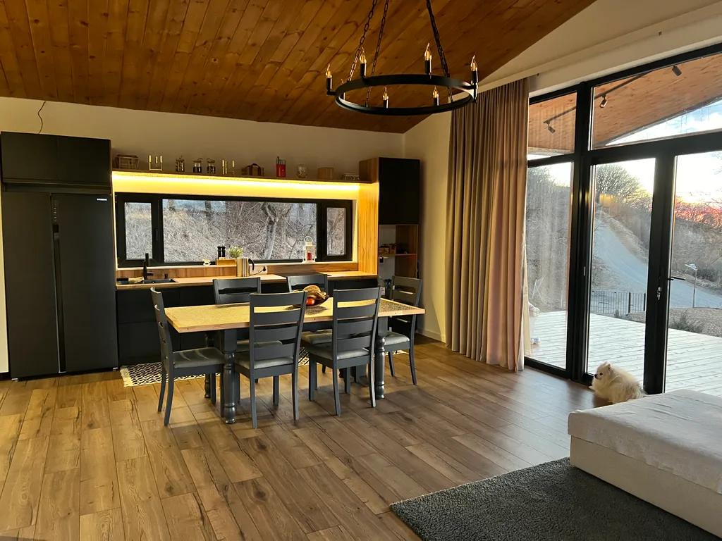 Домик на холме с видом на лес и горы