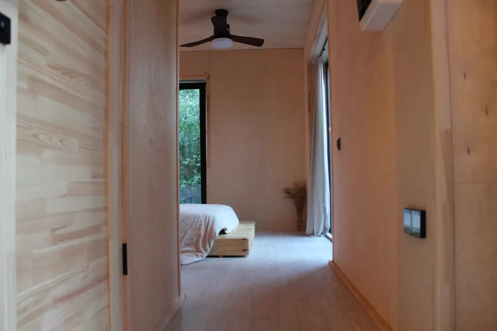 Дом с ванной у панорамных окон и высокой террасой в лесу