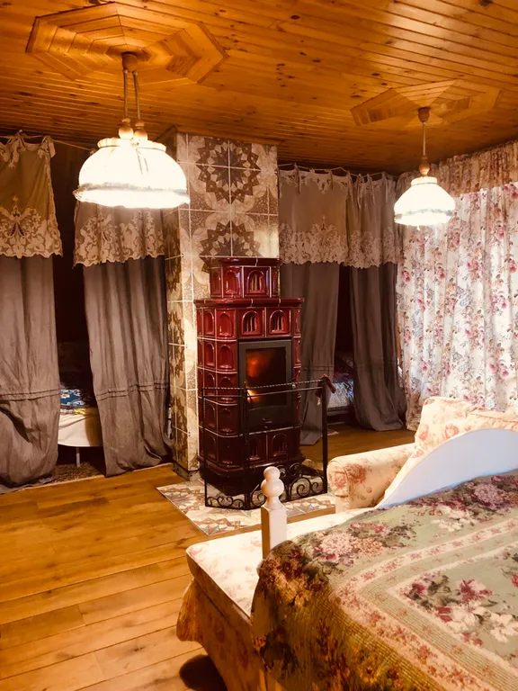 Изба (дом) из экологически чистого бревна под камышовой крышей в лесу