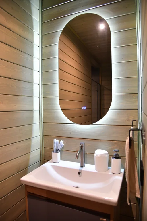 Дом с панорамными окнами в чаще леса у берега реки