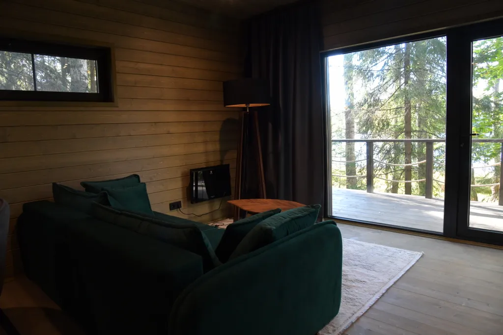 Дом с панорамными окнами в чаще леса у берега реки