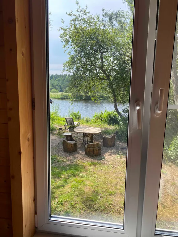 Деревянный дом на берегу реки с беседкой