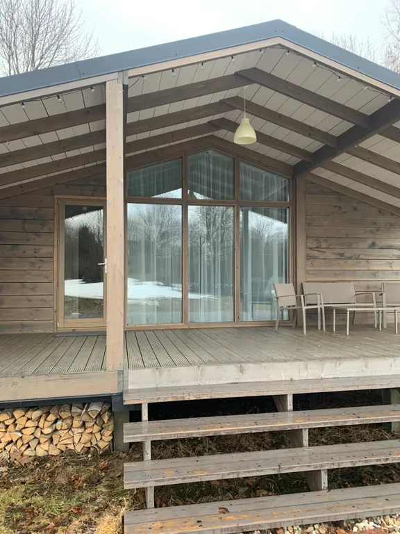 Дом с панорамными окнами в окружении леса