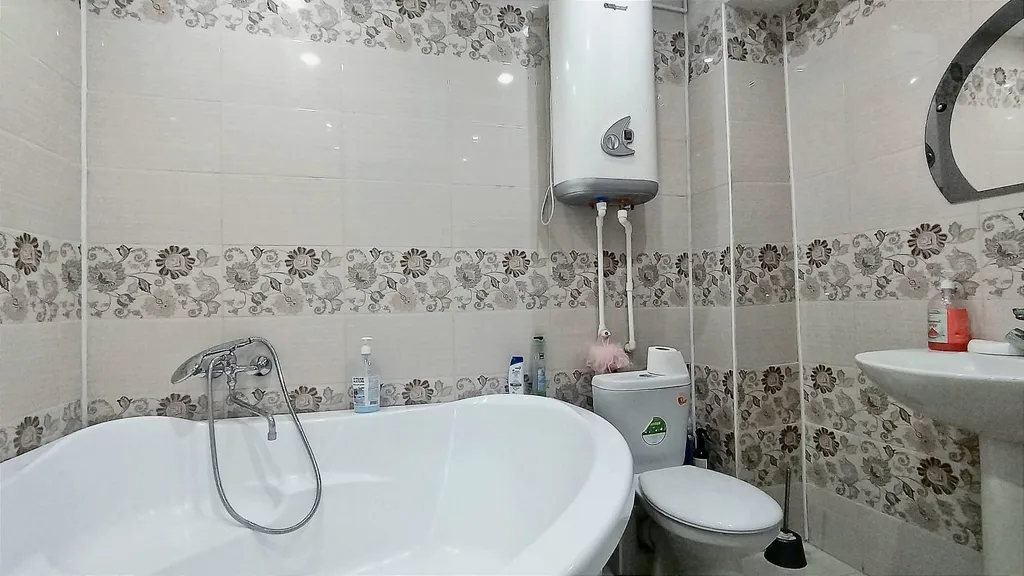 Уютная студия в тёплых тонах с большой угловой ванной для пары