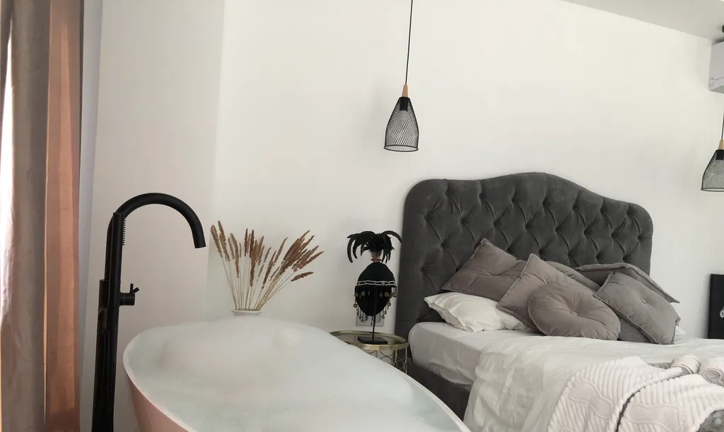 Стильная студия с ванной у панорамного окна и видом на горы