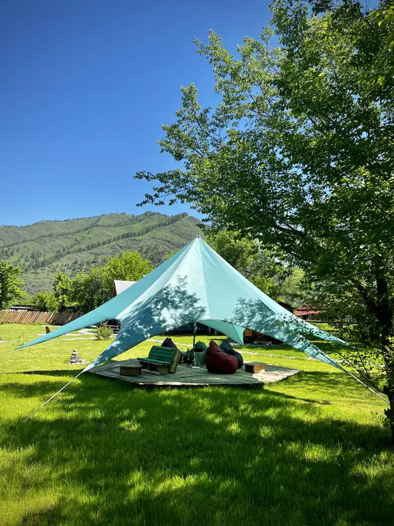 Уютный а-фрейм в сердце гор Алтая с видом на горы у леса