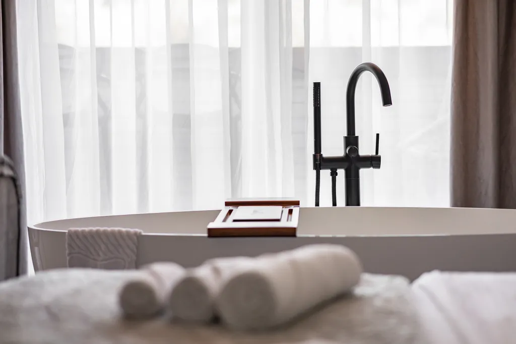 Стильная студия с ванной у панорамного окна и видом на горы