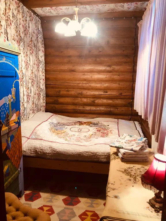 Изба (дом) из экологически чистого бревна под камышовой крышей в лесу