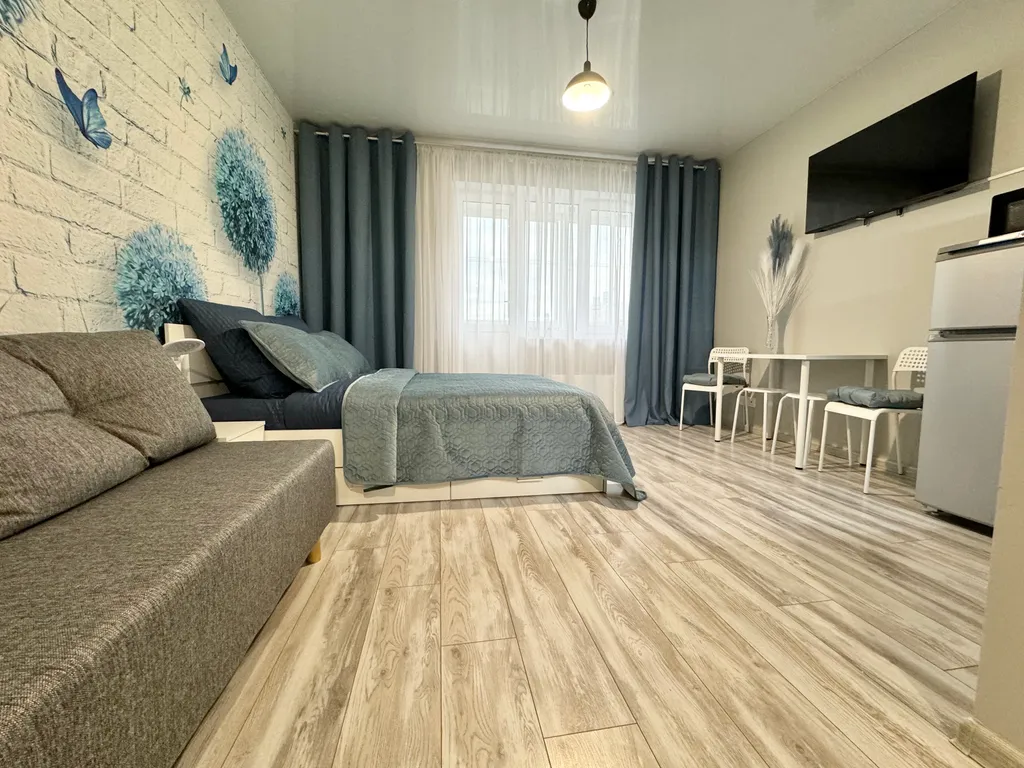 Уютная квартира-студия с большой кроватью и диваном