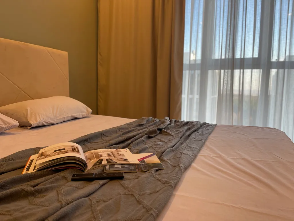 Новая квартира с кроватью возле панорамного окна, высокий этаж