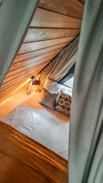 Треугольный домик на склоне горы над ручьём