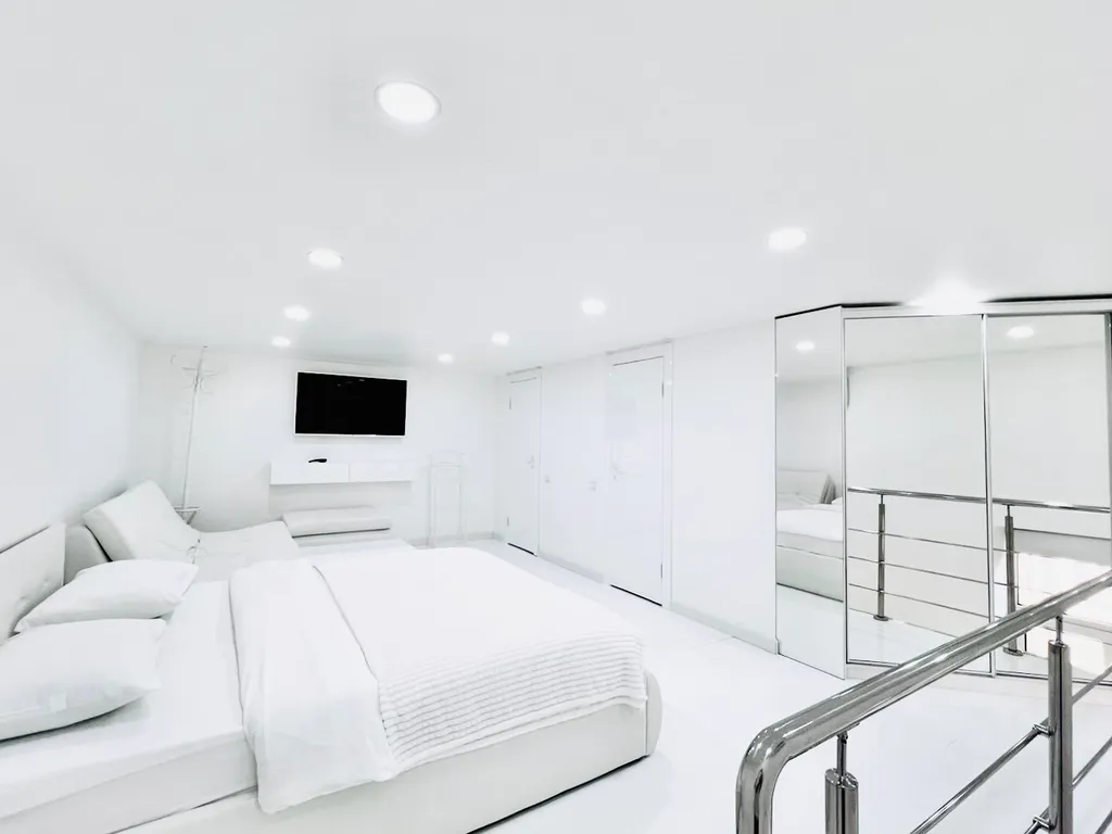 Белые двухъярусные апартаменты с балконом и видом на Невский проспект