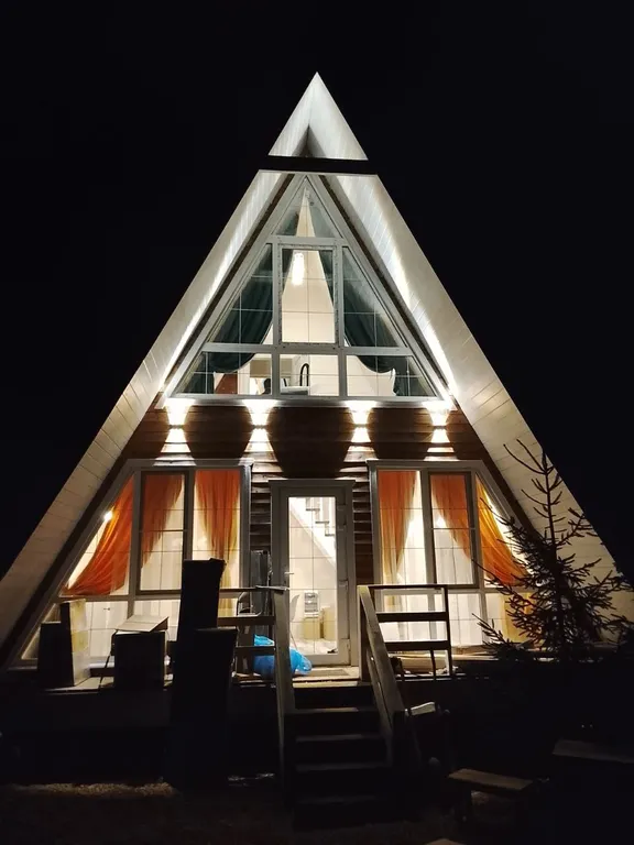 Большой дом А-Фрейм среди молодого елового леса