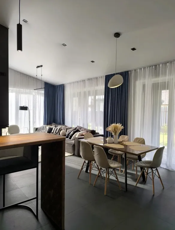 Новый дом в окружении елок с панорамными окнами и баней