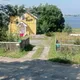 Въезд со стороны леса на стоянку. Вход в дом с красной дорожной для гостей.