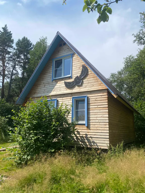 Деревянный дом на берегу реки с беседкой