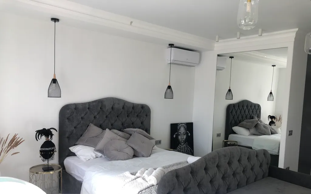 Стильная студия с ванной у панорамного окна и видом на горы