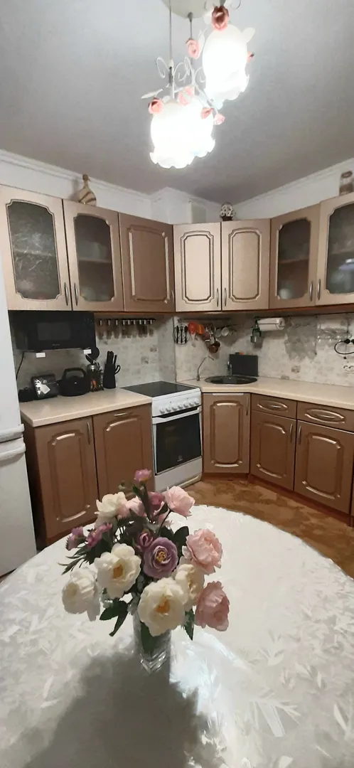 Кухонный гарнитур, холодильник, микроволновка, плита, раковина.