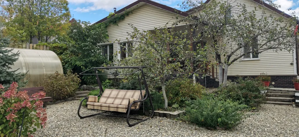 Уютный загородный дом с красивой благоустроенной территорией.