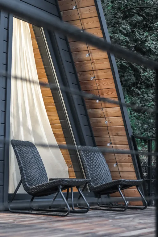 Треугольный домик на склоне горы над ручьём