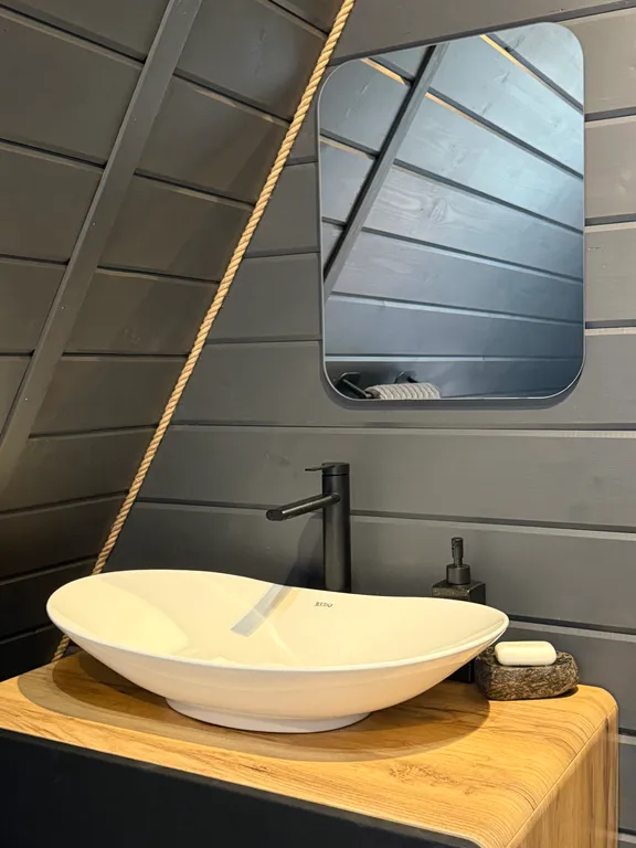 Большой треугольный домик с камином, с ванной у окна с видом на лес