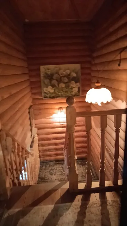 Изба (дом) из экологически чистого бревна под камышовой крышей в лесу