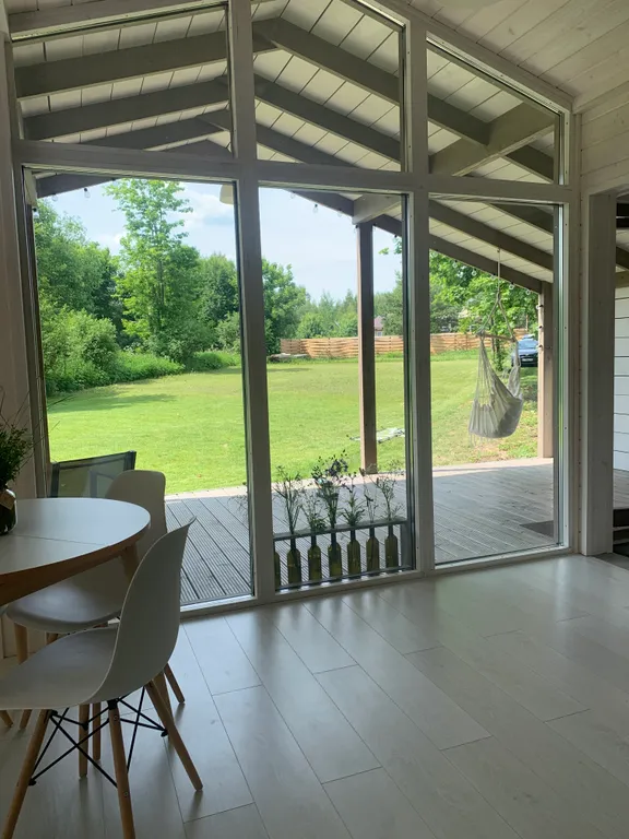 Дом с панорамными окнами в окружении леса