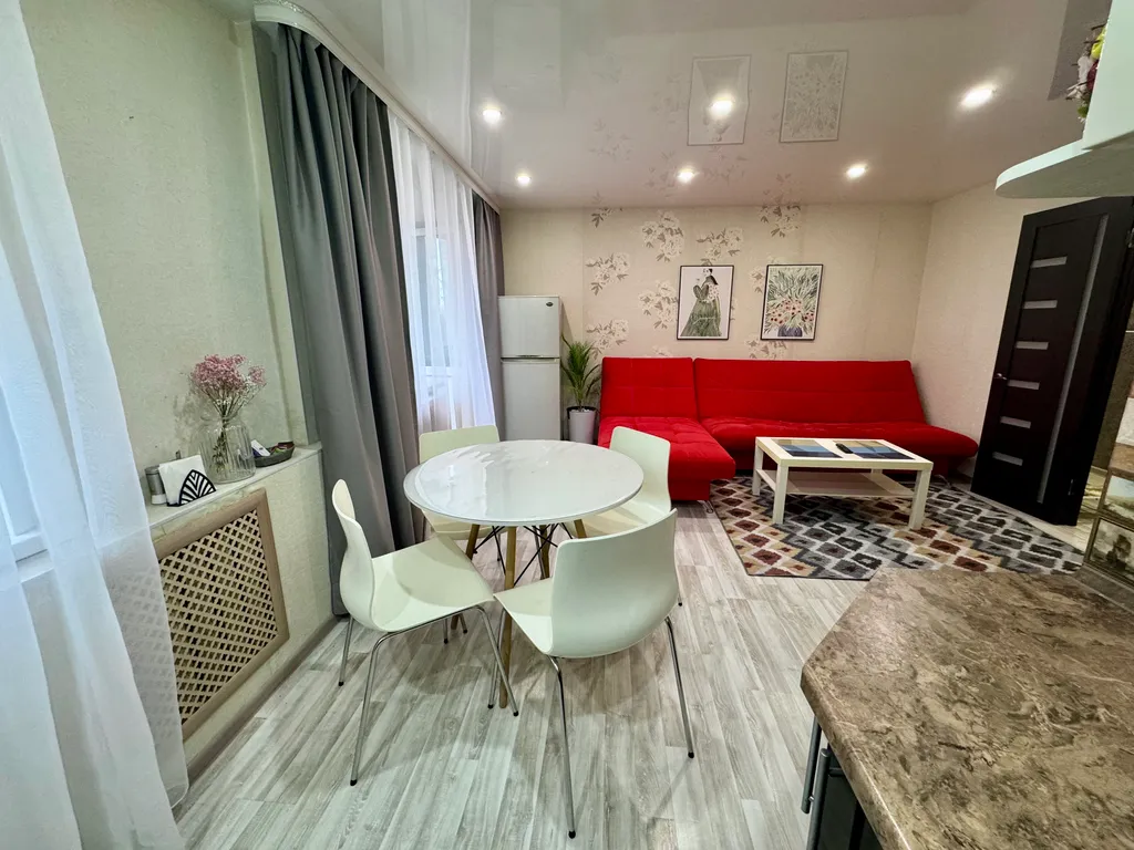 Двухкомнатная студия с красным диваном в центре города