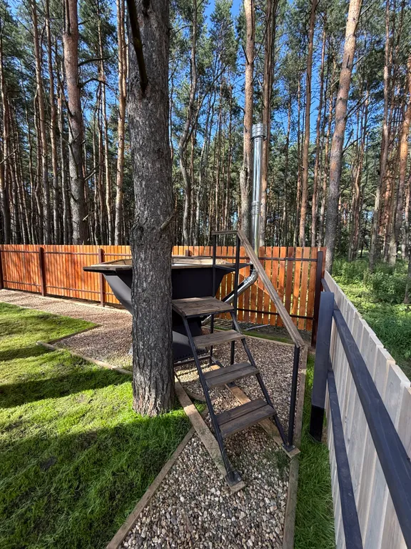 Большой треугольный домик с камином, с ванной у окна с видом на лес