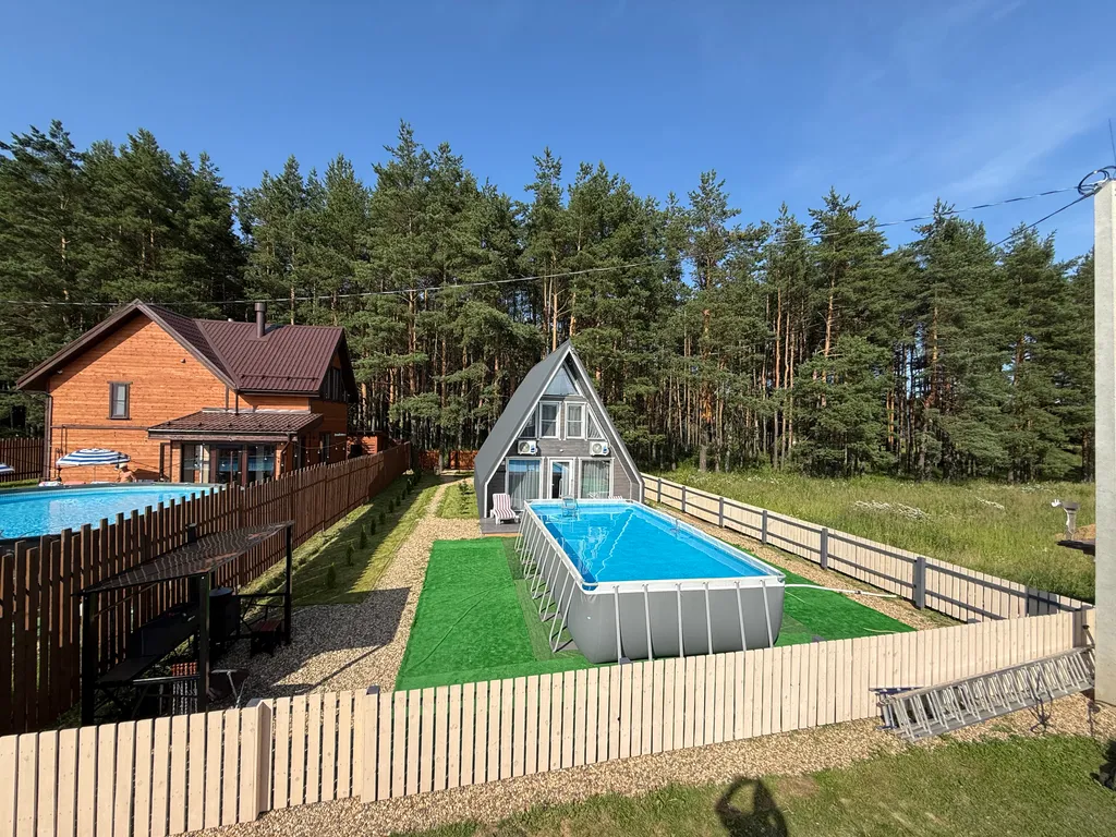 Большой треугольный домик с камином, с ванной у окна с видом на лес